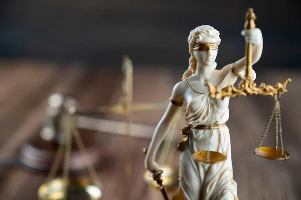 Law symbols composition. Themis statue, judges gavel and scale of justice on rustic wooden desk.