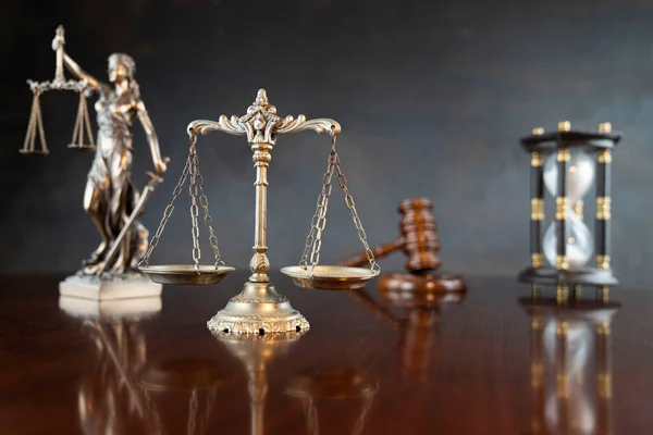 法律符号组成 闪闪发亮的褐色桌子和灰色背景上的主题雕像 法官槌和公正的尺度 — 图库照片