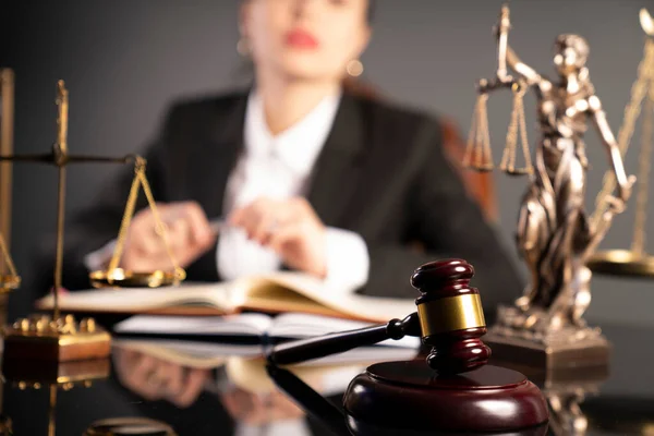 若い女性弁護士が商工会議所で働いている ギャベル テーマ像と茶色の輝く机の上のスケール — ストック写真