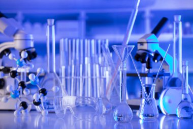 Coronavirus salgını teması. Hızlı covid testleri ve anti-covid aşısıyla ilgili bilimsel araştırma. Mavi arka planda deney tüpleri, mikroskop ve test tüpleri..