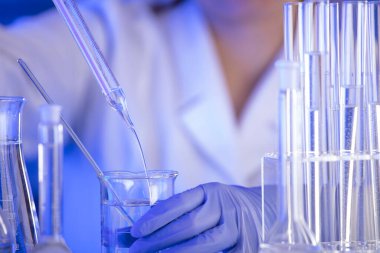 Coronavirus salgını teması. Hızlı covid testleri ve anti-covid aşısıyla ilgili bilimsel araştırma. Mavi arka planda deney tüpleri, mikroskop ve test tüpleri..