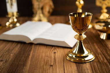 Katolik din sembolleri. Haç, Monstrance, İsa figürü, Kutsal İncil ve kırsal ahşap sunaktaki altın kadeh..