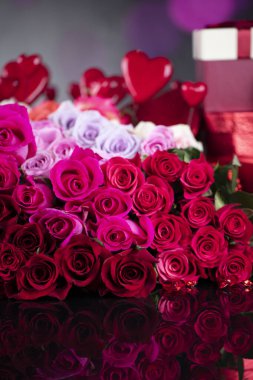 Düğün günü konsepti. Büyük bir buket gül ve cam masada düğün hediyeleri olan kutular..