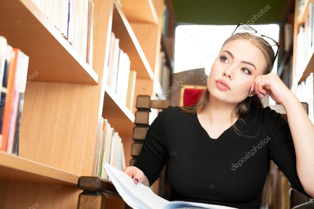 First day in school. Young female teacher preparing lecture in library.