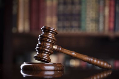 Hakimler kahverengi masa ve kitaplığın arka planında tokmak var. Hukuk ve adalet kavramı.