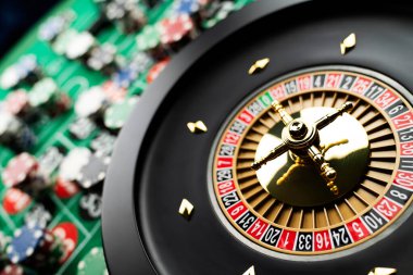 Kumarhane teması, ruleti kapat, kırmızı ve siyah numaralar. Arkaplanda çip yığını.