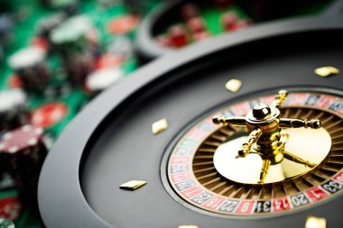 Kumarhane teması, ruleti kapat, kırmızı ve siyah numaralar. Arkaplanda çip yığını.