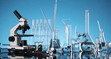 Coronavirus salgını teması. Hızlı covid testleri ve anti-covid aşısıyla ilgili bilimsel araştırma. Mavi arka planda deney tüpleri, mikroskop ve test tüpleri..