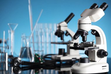 Coronavirus salgını teması. Hızlı covid testleri ve anti-covid aşısıyla ilgili bilimsel araştırma. Mavi arka planda deney tüpleri, mikroskop ve test tüpleri..