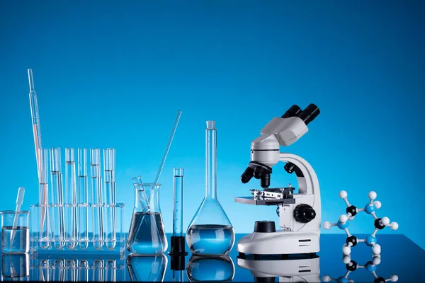 コロナウイルスのパンデミックをテーマに 高速Covid検査および抗Covidワクチンに関する科学的研究 青の背景にビーカー 顕微鏡 試験管 — ストック写真