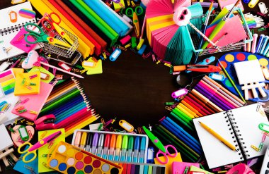 Okul malzemeleri. Kahverengi masada izole edilmiş renkli okul aksesuarları. Üst görünüm.