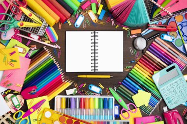 Okul malzemeleri. Kahverengi masada izole edilmiş renkli okul aksesuarlarının bileşimi. Üst görünüm.