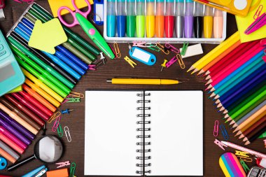 Okul malzemeleri. Kahverengi masada izole edilmiş renkli okul aksesuarlarının bileşimi. Üst görünüm.