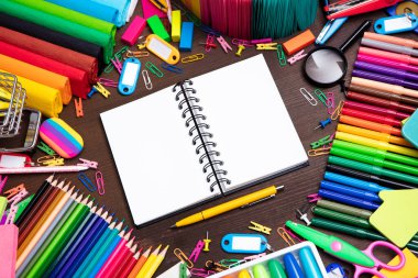 Okul malzemeleri. Kahverengi masada izole edilmiş renkli okul aksesuarlarının bileşimi. Üst görünüm.