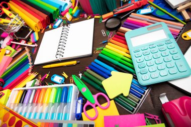 Okul malzemeleri. Kahverengi masada izole edilmiş renkli okul aksesuarlarının bileşimi. Üst görünüm.