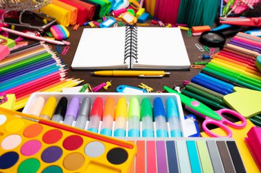 Okul malzemeleri. Kahverengi masada izole edilmiş renkli okul aksesuarlarının bileşimi. Üst görünüm.