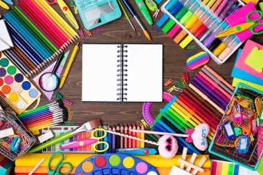 Okul malzemeleri. Kahverengi masada izole edilmiş renkli okul aksesuarlarının bileşimi. Üst görünüm.