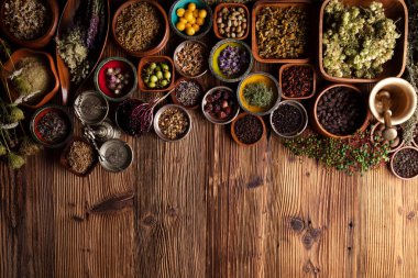 Doğal tıp geçmişi. Kâselerde çeşitli kuru otlar ve rustik ahşap masa üzerinde pirinç havan..