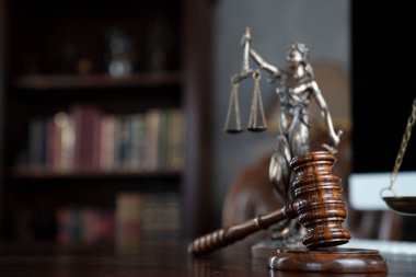 Hukuk teması. Yargıç odası. Kahverengi masanın üzerindeki tokmak ve tokmak. Kitaplıkta yasal kitap koleksiyonu.
