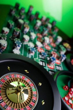 Kumarhane teması, ruleti kapat, kırmızı ve siyah numaralar. Arkaplanda çip yığını.