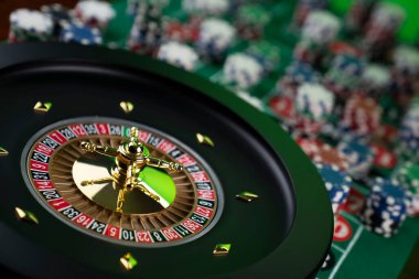 Kumarhane teması, ruleti kapat, kırmızı ve siyah numaralar. Arkaplanda çip yığını.