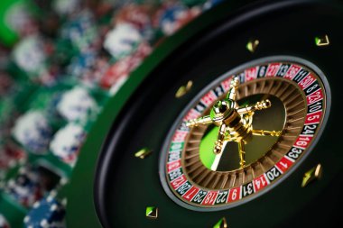 Kumarhane teması, ruleti kapat, kırmızı ve siyah numaralar. Arkaplanda çip yığını.