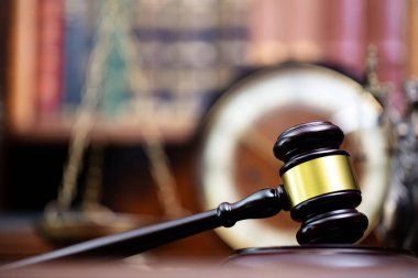 Hukuk teması. Yargıç odası. Hakimler kahverengi masasında tokmak var. Kitaplıkta yasal kitap koleksiyonu.