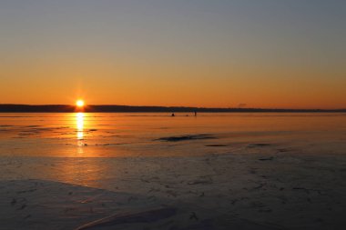 büyük bir nehir üzerinde kırmızı günbatımı. mesafe iki balıkçı vardır. Ufukta silueti.