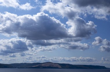 Tepenin yükseklikten büyük nehir manzarası. Mavi gökyüzünde parlak bulutlar. Dış görev dağlar.