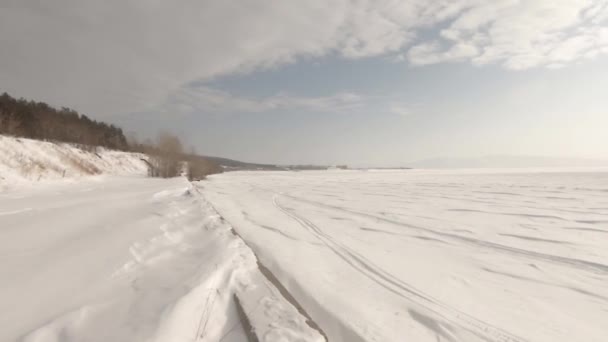 在山的地平线上 冰冻的河流和大量的雪 背光和明亮的阳光 慢速相机布线 — 图库视频影像