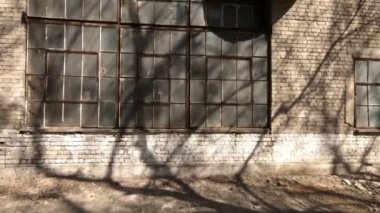 Eski fabrika dükkanının yüksek duvarı. Büyük pencere ve kırık cam. Kamera kablolama.