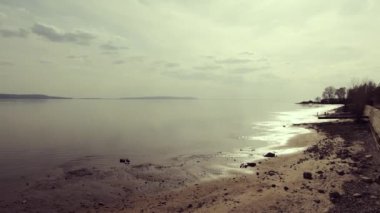 Büyük bir nehir boyunca bir panorama çekim. Dağın ufkunda. Yavaş kamera kablolama. Arka ışık ve parlak güneş.