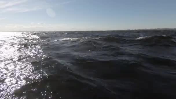 青い高波と雲の青い空 クローズ アップ きれいな海の空気 対向する太陽からの水に明るいまぶしさ — ストック動画
