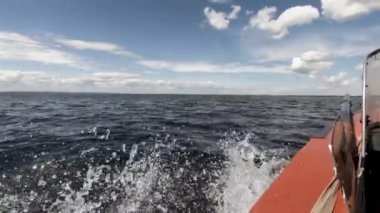 Denizde tekneyle hareket. Bir taraftan ateş ediyorlar. Uzak ufku, temiz havayı, dalgaları, akan suyu görebilirsiniz. Mesaj için yer var. Atmosferik video.