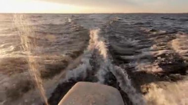 Denizde tekne ile hareket. Kıçından ateş ettim. Sen motor, uzak ufuk, temiz hava ve dalgalar, su sıçraması gelen uyanma görebilirsiniz. Metin alanı. Atmosferik video.