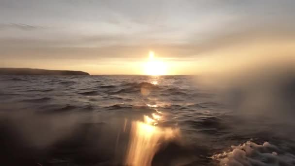 海上でのボートによる移動 片側から撮影 レンズに水が滴り 画像がぼやけます 地平線と夕焼けを見たきれいな空気と波が水をはねかけています テキスト用のスペース 大気ビデオ — ストック動画