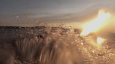 Denizde tekne ile hareket. Bir taraftan çekim. Lens ve bulanık görüntü su düşer. Ufuk ve gün batımı gördüm. Temiz hava ve dalgalar su sıçrayan. Metin alanı. Atmosferik video.
