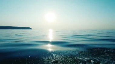 Denizde tekne ile hareket. Bir taraftan çekim. Günbatımı. Sen uzak ufukta görebilirsiniz, temiz hava ve dalgalar, su sıçraması. Elmas damlası gibi şeffaf. Metin alanı. Atmosferik video.