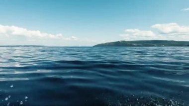 Denizde tekneyle hareket. Bir taraftan ateş ediyorlar. Uzak ufku, temiz havayı, dalgaları, akan suyu görebilirsiniz. Mesaj için yer var. Atmosferik video.