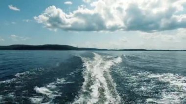 Denizde tekne ile hareket. Kıçından ateş ettim. Sen motor, uzak ufuk, temiz hava ve dalgalar, su sıçraması gelen uyanma görebilirsiniz. Metin alanı. Atmosferik video.