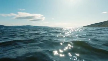  Temiz hava, sakin dalgalar ve su üzerinde küçük dalgalanmalar. Yüksek beyaz bulutlar. Metin için boşluk. Atmosferik video.