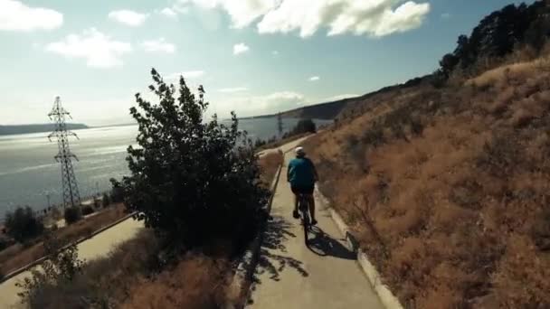Девушка Едет Велосипеде Высокого Берега Городской Набережной Большой Рекой Стреляли — стоковое видео