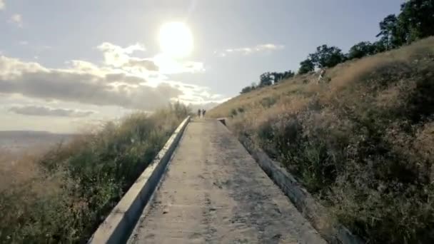 자전거를 소녀가 걸어서 올라간다 아래는 제방과 강입니다 뒤에서 공기를 깨끗이 — 비디오