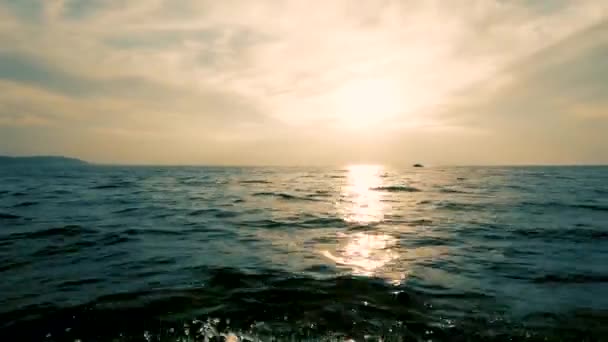 海上でのボートによる移動 片側から撮影 海岸の暗いシルエット 遠くの地平線 きれいな空気と波 水をはねることができます テキスト用のスペース 大気ビデオ ボートが遠くに浮いている — ストック動画
