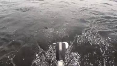  Büyük nehir. Teknenin kıç tarafında bir motor var. Bir vida yakın planda görünür. Uzak ufuk, sahil ve bulutlar. Temiz su ve temiz hava..