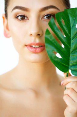 Cilt Bakımı. Yeşil yaprakları ile güzel bir kız. Güzellik bakımı. Kozmetik. Güzellik Spa salonları