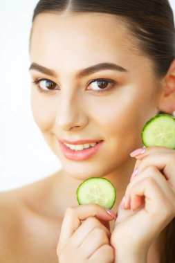 Cilt Bakımı. Mutlu seksi kadın ellerinin beyaz arka plan üzerinde içinde salatalık dilimleri ile poz. Güzellik bakımı. Kozmetik. Güzellik Spa salonları