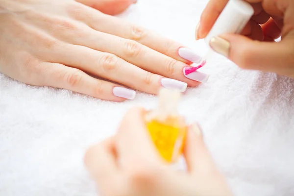 Beauty and Care. Manicure Master Applying Nail Polish in Beauty Salon. Beautiful Women's Hands with Perfect Manicure. Spa Manicure.