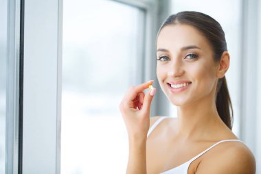 Beslenme. Sağlıklı bir yaşam tarzı. Balık yağı Omega-3 hap tutan kadın. Takviyeleri, vitaminler.