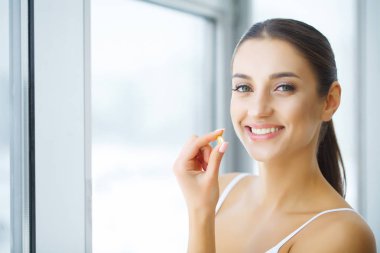 Beslenme. Sağlıklı bir yaşam tarzı. Balık yağı Omega-3 hap tutan kadın. Takviyeleri, vitaminler.